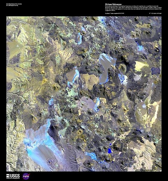 This enhanced satellite image shows a field of dormant volcanoes on the border between Chile and the Catamarca province of Argentina. The photo is tinged with various colors that can indicate both the age and mineral content of the original lava flows. Some arroyos and alluvial fans may be seen in the upper left. Image courtesy of USGS.