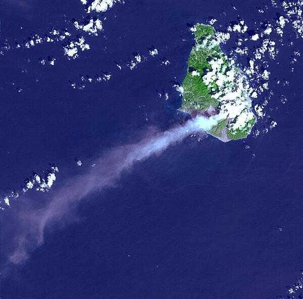 Eruptive activity of the Soufriere Hills Volcano on Montserrat is evidenced by an extensive smoke and ash plume streaming towards the west-southwest (image taken 29 October 2002). Significant eruptive activity began in 1995, forcing the authorities to evacuate about two-thirds of the island&apos;s original population of 12,000, and to close off the southern portion of the island. Image courtesy of NASA.