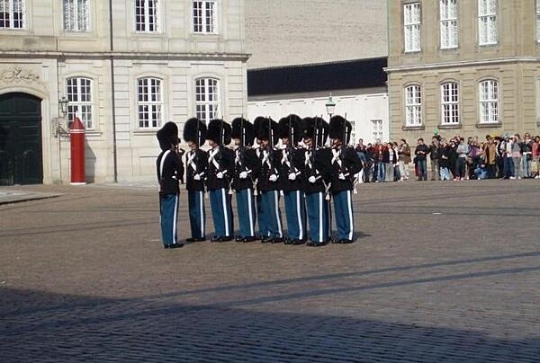 Changing of the guard in the large octagonal courtyard of the Amalienborg Palace in Copenhagen, Denmark. Bordering the plaza are four buildings with identical facades that serve as the winter home of the royal family.