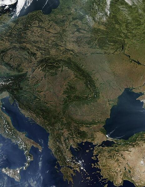 A virtually cloud-free view of Central Europe vividly displays the fishhook-shaped Carpathian Mountains that snake through the middle of the continent. This view includes Poland, the Czech Republic, Slovakia, Hungary, Romania, Slovenia, Greece, and all of the Balkan countries. Large parts of Lithuania, Belarus, Ukraine, Turkey, and Italy are also visible. Scattered fires are visible as red dots. Image courtesy of NASA.