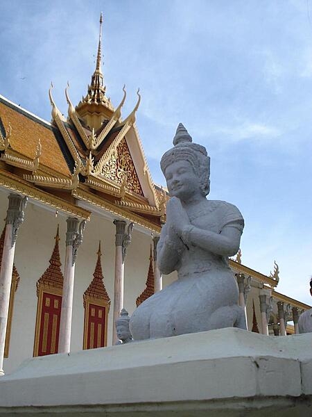 Kneeling figure beside the Silver Pagoda on the Royal Palace grounds in Phnom Penh, Cambodia. The Silver Pagoda lies on the south side of the palace complex. The main building houses many national treasures, including gold and jeweled Buddha statues.