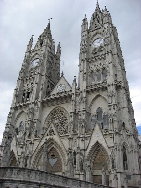 The front façade of the Basilica of the National Vow (Basílica del Voto Nacional) in Quito, Ecuador. Construction began in 1892, and the formal consecration occurred in 1988. The basilica remains technically unfinished, since, according to local legend, its completion would signal the end of the world. The edifice is the largest Neo-Gothic basilica in the Americas.