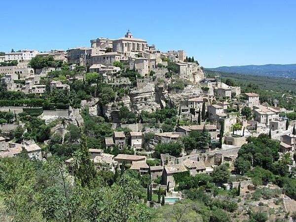 View of Gordes in Provence, France. The buildings are constructed of white stones and rise in tiers above the Imergue Valley on the edge of the Vaucluse Plateau.