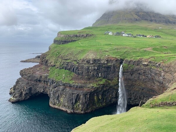 The Faroe Islands are an autonomous territory of Denmark, and one of the most iconic sights is the Mulafossur waterfall, situated on Vagar Island. The North Atlantic archipelago is located 320 km (200 mi) north-northwest of Scotland, and about halfway between Norway and Iceland. The islands have a total area of about 1,400 sq km (540 sq mi).