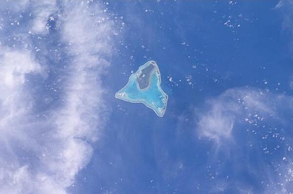 Aitutaki in the Southern Cook Islands has a distinctive equilateral triangular shape that is roughly 12 km (7.5 mi) on each side. It is an "almost atoll" whose coral reef barrier does not extend above the ocean along its southern side. Image courtesy of NASA.