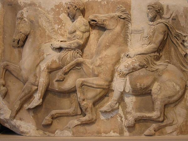 Sculpted processional riders from the marble frieze of the Parthenon in Athens, Greece.