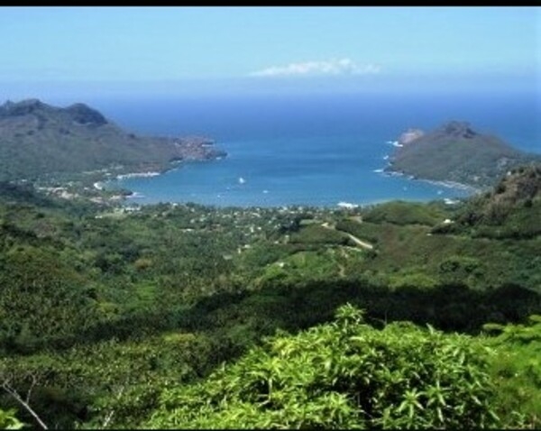 The view overlooking Baie Taiohae on Nuku Hiva in the Iles Marquesas in French Polynesia. The settlement of Taiohae is in the middle of the photo at the end of the bay. It is the largest settlement on Nuku Hiva. Photo courtesy of NOAA/ Lieutenant Rebecca Waddington