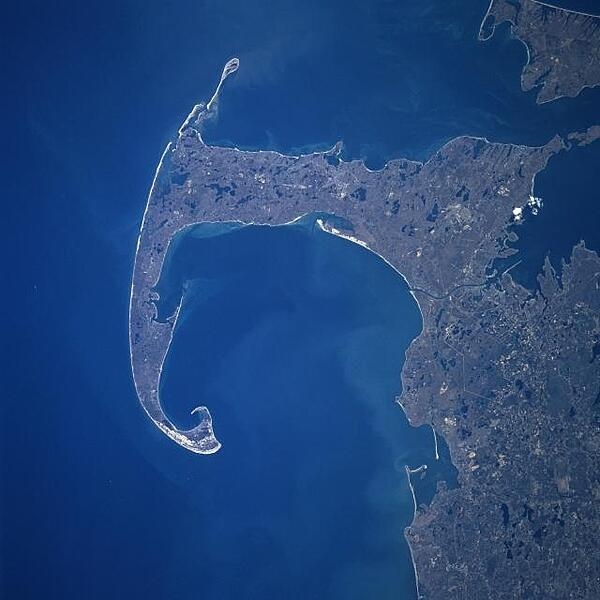 Cape Cod and Cape Cod Bay (visible at the center of the image) can be seen in this south-looking view. Cape Cod extends 105 km (65 mi) east and north into the Atlantic Ocean. A portion of Martha&apos;s Vineyard can be seen in the upper-right corner of the image. Photo courtesy of NASA.