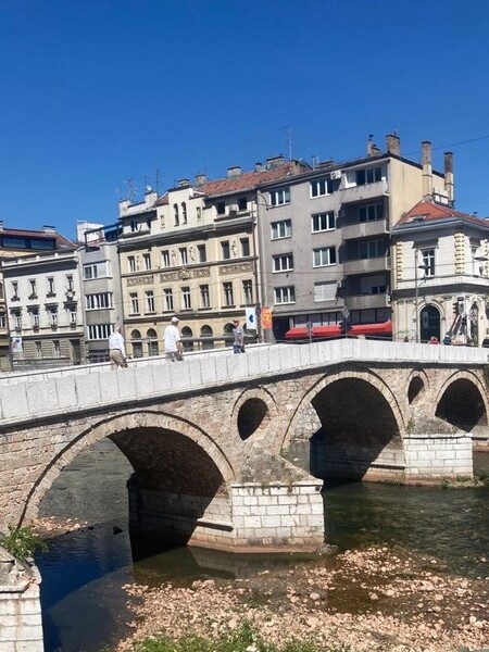 The Latin Bridge is the oldest of over a dozen bridges crossing the Miljacka River in Sarajevo in Bosnia and Herzegovina. The original wooden bridge dates to around 1541 but was replaced by a stone structure in 1565.  After a flood, it was rebuilt around 1798. The bridge acquired its name because it connected to the Catholic quarter of the city (“Latinluk”). At the foot of the bridge on June 28, 1914, Serb nationalist Gavrilo Princip shot and killed Franz Ferdinand, heir presumptive to the Austro-Hungarian throne, sparking  WWI.