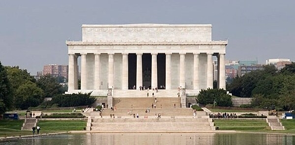 The Lincoln Memorial in Washington, D.C., dedicated in 1922, is modeled after the Parthenon in Athens, Greece. Architect Henry Bacon believed a memorial dedicated to a man who defended democracy should echo the birthplace of democracy.   The iconic memorial constructed with Colorado Yule marble is 30 m tall (99 ft), 57.m long (190 ft), and 36.5 m wide (120 ft) surrounded by 36 fluted Doric columns, one for each of the 36 states in the Union at the time of Lincoln's death.  The 5.8 m high (19 ft) statue of Lincoln sitting in quiet contemplation, designed by sculptor Daniel Chester French, is located between the north and south chambers of the memorial.  The Lincoln Memorial is the most popular monument on the National Mall and it is the only monument pictured on US currency (on the penny and the five-dollar bill).
Photo courtesy of the National Park Service/Carol Highsmith.