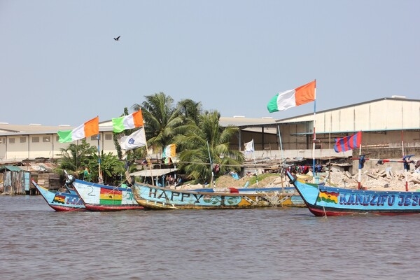 Côte d'Ivoire’s distinctive tri-color flag flies on the prows of various boats anchored in Abidjan harbor.