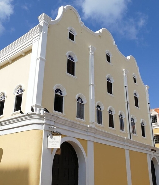 The Mikvé Israel-Emanuel (The Hope of Israel-Emanuel) synagogue in Willemstad, Curaçao, was consecrated in 1732 and is the oldest synagogue in continuous use in the Americas.  It was established by Spanish and Portuguese Jews from the Netherlands and Brazil who traced their roots back to the Iberian Peninsula in the 1500s. The synagogue floors are covered in sand, per Dutch-Portuguese Jewish tradition, reminding congregants of the 40 years the Jews spent wandering the desert in biblical times and how Portuguese ancestors muffled sounds of sacred prayers and song during the Inquisition. Willemstad was designated a UNESCO World Heritage site in 1997 for its colorful and historical Dutch colonial architecture that includes the Mikvé Israel-Emanuel synagogue.
