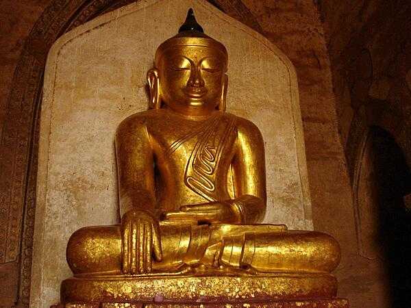 A golden Buddha statue sits in one of the many pagodas in Bagan, Burma.