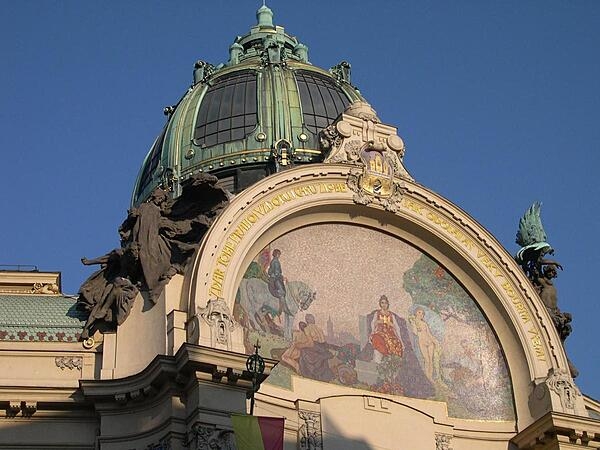 The Municipal House (Obecni Dum) is a national cultural landmark and the premier Art Noveau building in Prague, Czechia. Opened in 1912 on Republic Square, it houses a concert hall and an elegant French restaurant. Shown is the large exedra under the main cupola of the building, with its colorful glass mosaic depicting The Apotheosis of Prague.