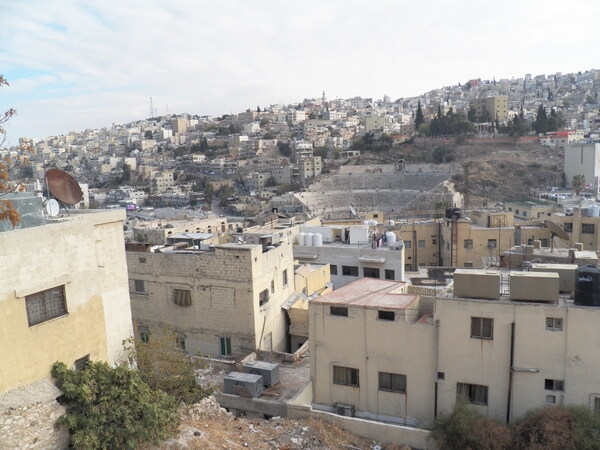 A view of Amman, Jordan, and the Roman Theater, which was built between A.D. 138 and 161 in honor of Roman Emperor Antoninus Pius.  The Roman Theater also houses the Amman Folklore Museum and the Amman Museum of Popular Traditions, both located in a series of rooms behind the two ground-level entrances.