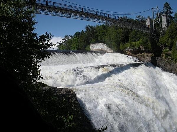 Montmorency Falls forms at the mouth of the Montmorency River as it drops over a cliff shore into the St. Lawrence River. The waterfalls are the highest in Canada's province of Quebec.