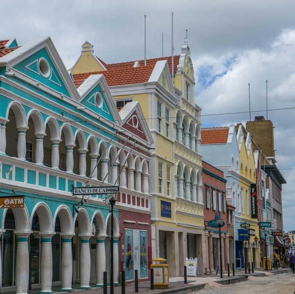 The historic area of Willemstad, Curacao’s capital city, began as colonial trading and administrative settlement established by the Dutch in 1634 with the construction of Fort Amsterdam on Sint Anna Bay. Willemstad’s architecture is influenced not only by its Dutch colonial roots, but also by the tropical climate and styles from towns throughout the Caribbean region which were trading partners. The red, blue, yellow ochre, and green on Willemstad buildings date from 1817 when the previous white lime finish was prohibited to protect eyesight from the glare. In 1997 Willemstad was recognized as a UNESCO World Heritage site.