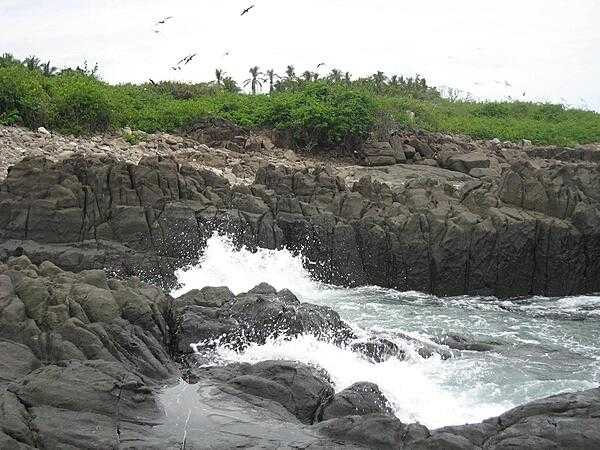 The rocky coast of Iguana Island on the Pacific coast of Panama.  Sparsely inhabited by humans, this wildlife refuge teems with bird and marine life.