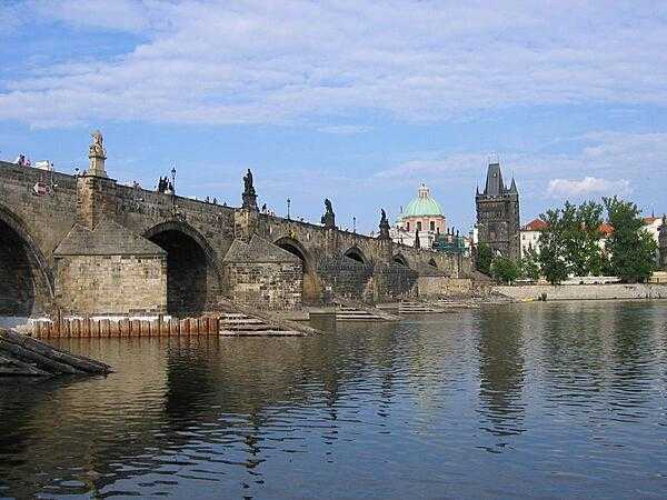 A riverside view of Charles Bridge in Prague, Czechia, showing the ice guards that protect the pillars.