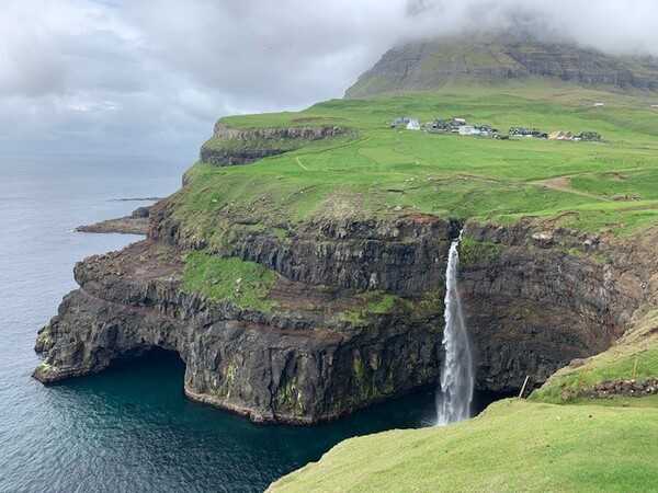 The Faroe Islands are a North Atlantic archipelago located 320 Km (200 mi) north-northwest of Scotland, and about halfway between Norway and Iceland; they are an autonomous territory of Denmark. The islands have a total area of about 1,400 square Km (540 sq mi). One of the island’s most iconic sites is the Mulafossur waterfall, situated on Vagar Island. The waterfall is over 30 meters (100 feet) high.