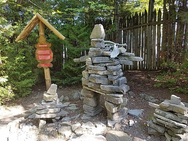 Inukshuks are structures of rough stones stacked in the form of human figures, traditionally used by Inuit people as a landmark or a commemorative sign. These are located at the replica Wendat (Huron) village outside Quebec City, Canada.