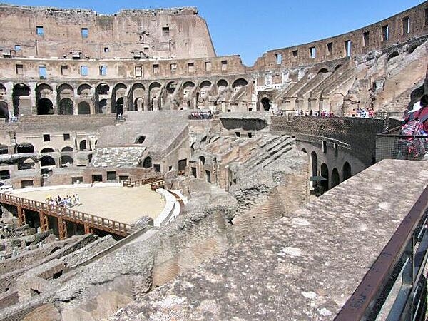 The arena of the Colosseum in Rome, Italy, was a wooden floor covered with sand, with rooms and passageways underneath for performers, sets, and animals. Spectator seating was divided into three sections: ordinary people sat in the upper level, the better-off in the middle sections, and the elite in the lower level.