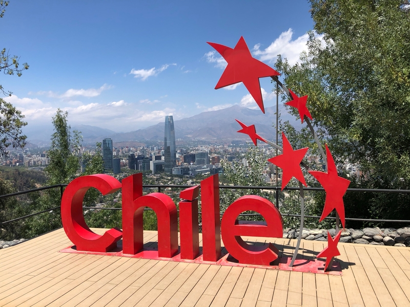 An overlook and sculpture along the walking trail above the business center in Santiago, Chile, provides an expansive view. At over 300 m (980 ft), Torre Costanera, shown in the background, is one of the tallest buildings in the southern hemisphere.