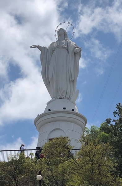 The statue of the Immaculate Conception of the Virgin Mary sits on San Cristobal Hill in the Metropolitan Park, overlooking the city of Santiago, Chile. The park includes miles of walking trails, a gondola, and other attractions and is popular with locals on the weekends.