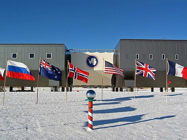 Amundsen-Scott South Pole Station in the 2007-2008 summer season. In the foreground is the ceremonial South Pole and the flags for the original 12 signatory nations to Antarctic Treaty. Photo courtesy of the National Science Foundation/ Bill Spindler.